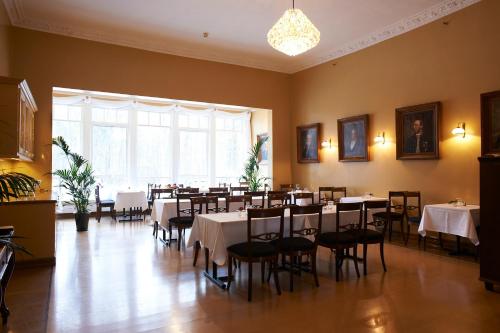uma sala de jantar com mesas e cadeiras e uma grande janela em Sjømilitære Samfund em Horten