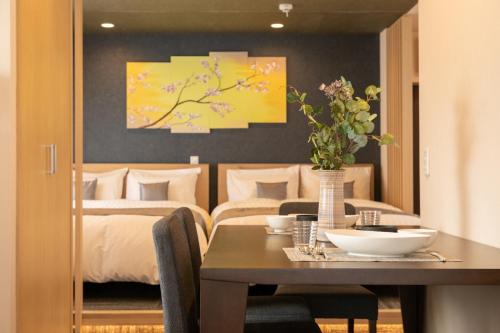 a bedroom with a bed and a table with flowers on it at Sakura Stay Yoga 301 in Tokyo