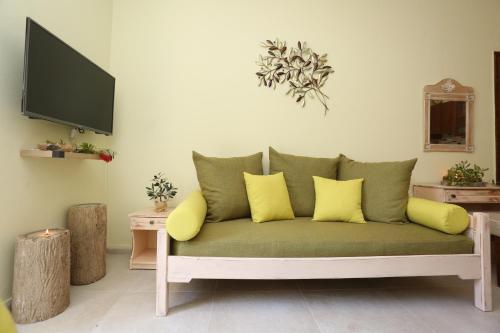 a living room with a green couch with yellow pillows at Elia in Skála Foúrkas