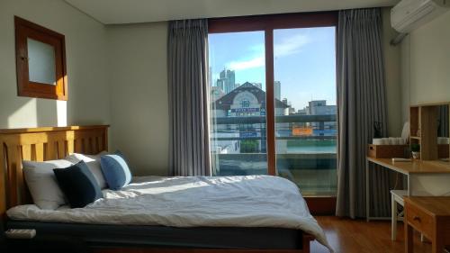 a bedroom with a bed and a large window at Dolma Hongdae in Seoul