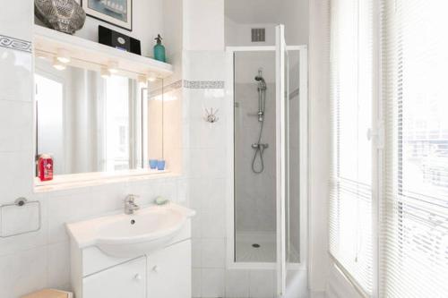a white bathroom with a shower and a sink at Charming bedroom in Paris