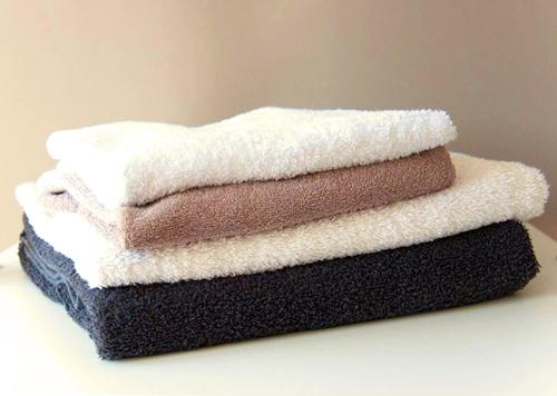 three towels stacked on top of each other on a table at Residence Flower Market in Amsterdam
