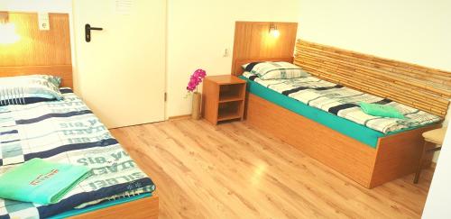 2 aparte bedden in een kamer met houten vloeren bij Pension Haus Baron 1 Neckarau in Mannheim