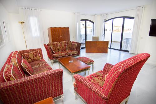 a living room filled with furniture and a red couch at Park Plaza Suites Apartamentos in Marbella