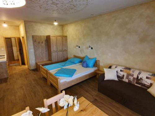 een slaapkamer met een bed en een bank in een kamer bij Apartmaji Bršca in Begunje na Gorenjskem