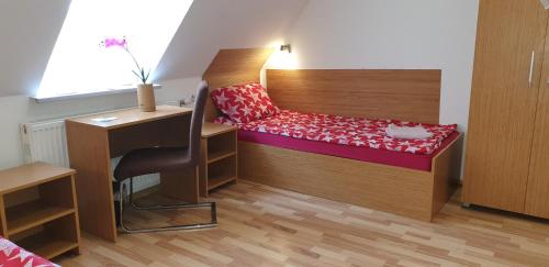 a small room with a bed and a desk at Pension Haus Baron 1 Neckarau in Mannheim