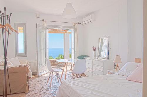 Petriaí的住宿－Villa Von Sophia，一间卧室设有一张床铺和一张桌子,享有海景