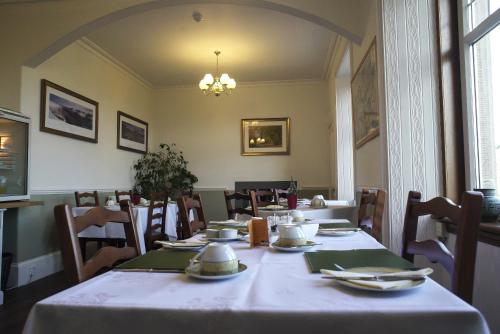 Firtree Bed and Breakfast at Galvelbeg House في كريف: غرفة طعام مع طاولة مع قطعة قماش بيضاء
