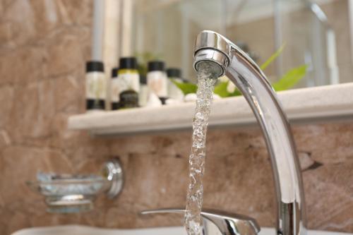 a bathroom sink with water running from a faucet at Elia in Skála Foúrkas