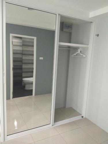 a mirror in a bathroom with a toilet at Asia's Beach Apartments in Sattahip