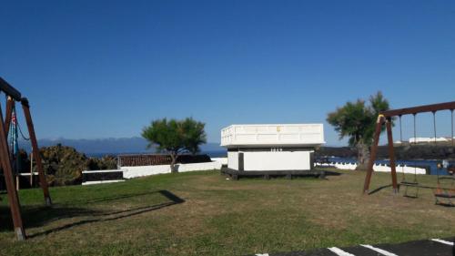 a park with two swings and a bench at Azores Hibiscus House - Mountain and Sea in São Roque do Pico