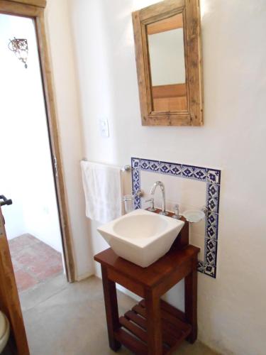 a bathroom with a white sink and a mirror at Hosteria Villa Cardon in Cachí
