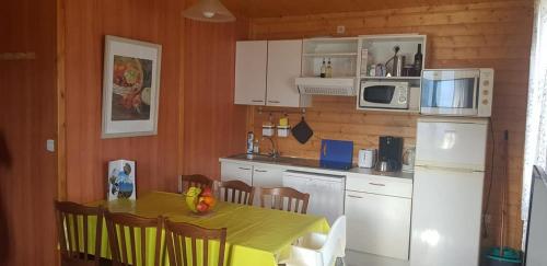 Ignaux的住宿－ISATIS 19，厨房配有桌子和白色冰箱。