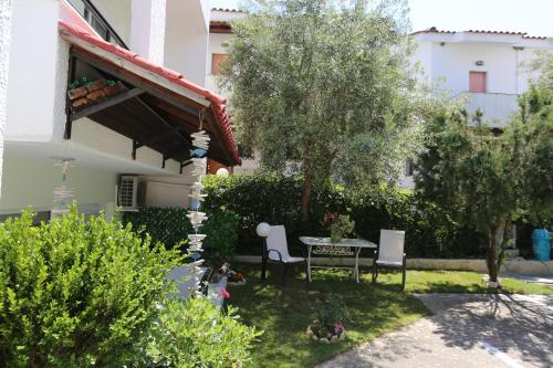 a garden with a table and chairs and trees at Elia in Skála Foúrkas