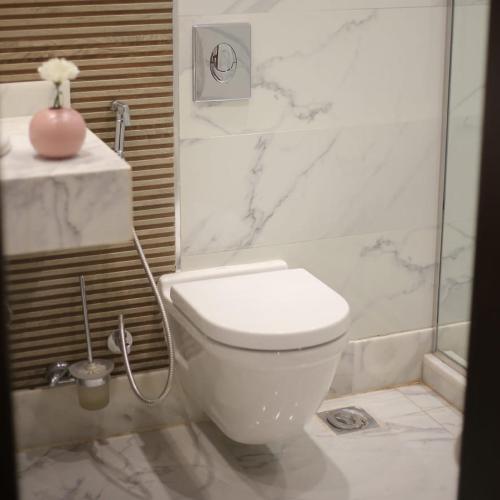 a white bathroom with a toilet and a shower at Apartment in Mohandesin (Families Only) in Cairo