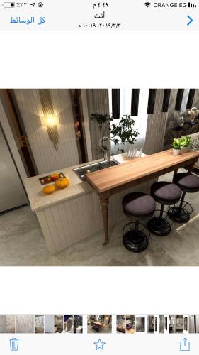 a kitchen with a table and a sink and some stools at Apartment in Mohandesin (Families Only) in Cairo