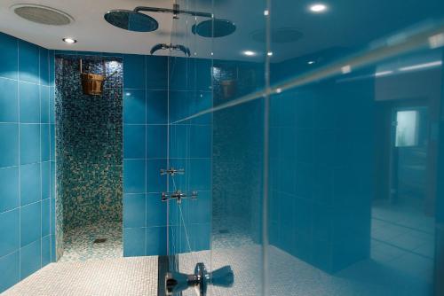 a bathroom with a shower with blue tiles at Parkhotel St.Leonhard in Überlingen
