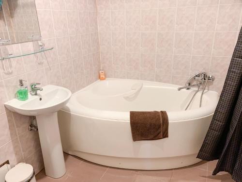 a bathroom with a white tub and a sink at City Inn Riga Apartment, Old Town History Heritage with parking in Rīga