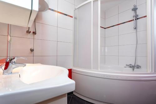 a white bathroom with a sink and a shower at Apartments Mia in Baška