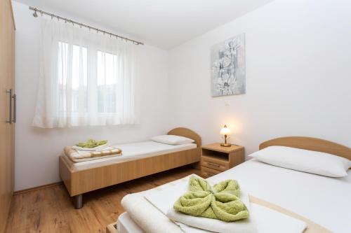 a bedroom with two beds and a window at Apartments Mia in Baška