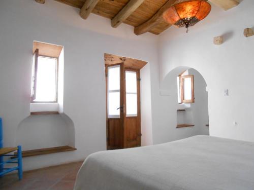 a white room with a bed and two windows at Hosteria Villa Cardon in Cachí