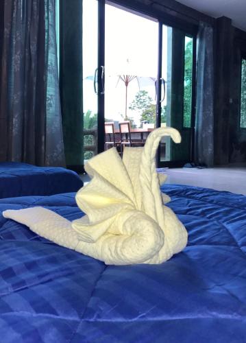 a swan made out of towels on a bed at Rai Phusaitran ไร่ภูสายธาร in Mae Taeng