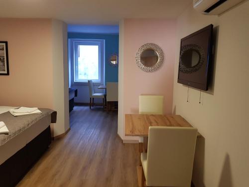 a room with a table and a bed and a table and chairs at Piraneska in Piran