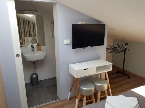 bagno con lavandino e TV a parete di Piraneska a Piran