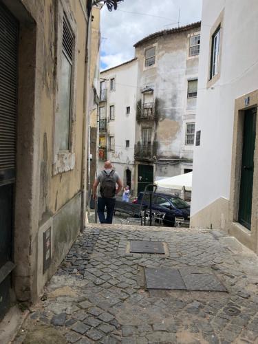 Ein Mann, der in einer Gasse die Straße hinuntergeht. in der Unterkunft Heart of Alfama in Lissabon