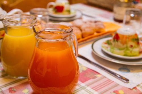 un tavolo con 2 bicchieri di succo d'arancia di Guest House Il Nido dello Svasso -Foresteria Lombarda- a Sorico