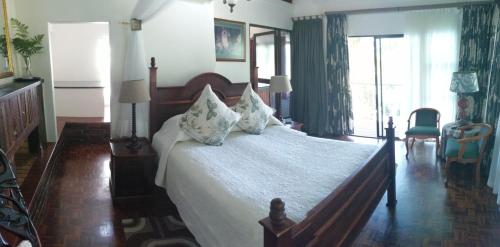 a bedroom with a large bed with white sheets and pillows at St. Lucia Wetlands Guest House in St Lucia