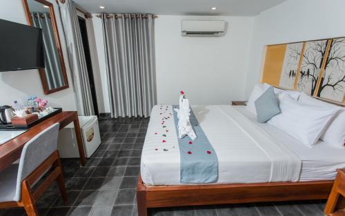 a hotel room with a bed with roses on it at Home Chic Hotel in Phnom Penh