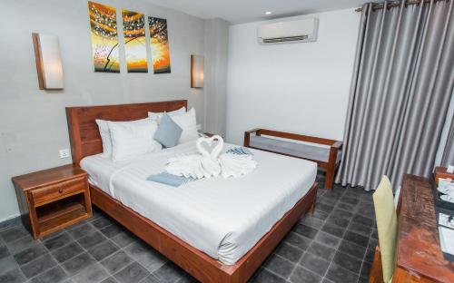 a bedroom with a bed with a towel on it at Home Chic Hotel in Phnom Penh
