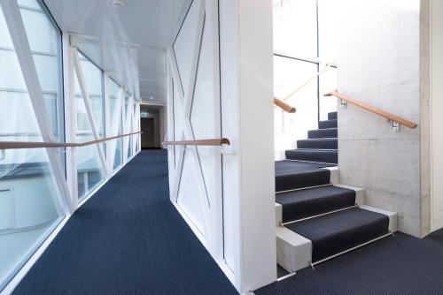 a staircase in an office building with black carpet at Hotel Krone Unterstrass in Zürich