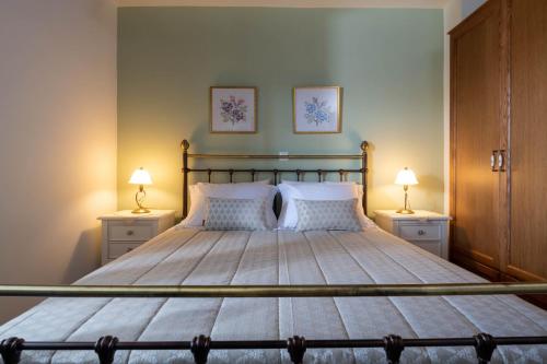 a bedroom with a large bed with two lamps at Cretan Minoan Apartments in Zákros