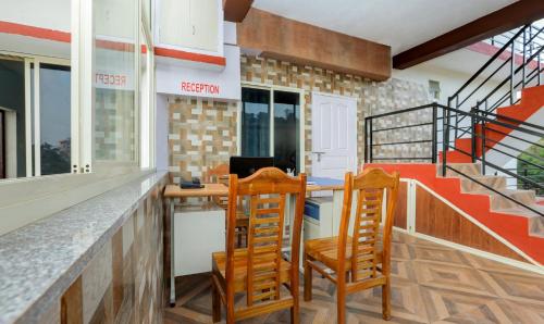 a kitchen with a counter with two chairs and a desk at Daisey Dee Homestay in Madikeri