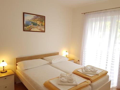 a bedroom with a bed with two towels on it at Apartments Mira in Baška