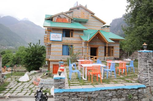 una casa con mesas y sillas frente a ella en Snow River, Manali, en Manali