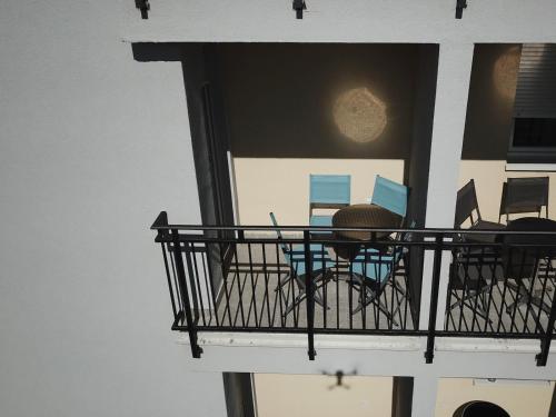 a balcony with chairs and a table on it at Apartmani Pezerović in Soko Banja