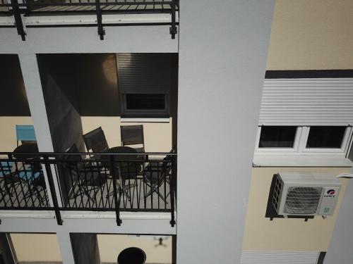a balcony with a table and chairs and a heater at Apartmani Pezerović in Soko Banja