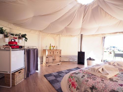 une chambre avec un lit et une tente dans l'établissement Old Dairy Farm Glamping, à Emsworth