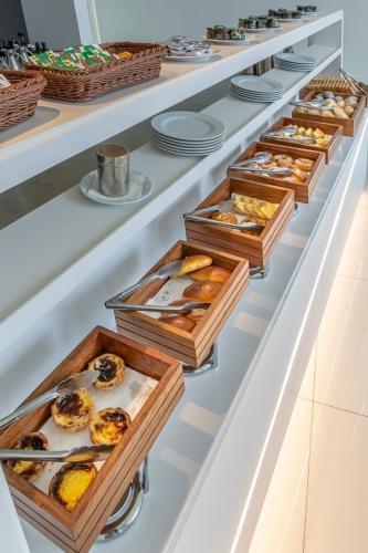 a bakery display case with trays of pastries at Meliá Maputo Sky in Maputo