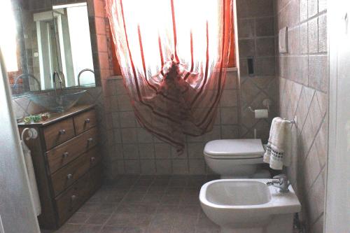 a bathroom with a toilet and a sink and a mirror at Antico Casale dei Mercanti in Montefiascone