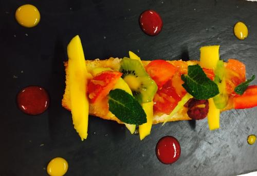 a slice of pizza with vegetables and fruit on a table at Auberge Du Cheval Blanc in Beaumont-Pied-de-Boeuf