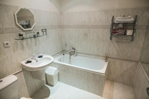 a bathroom with a sink and a tub and a toilet at Hotel Dejmalik in Litoměřice