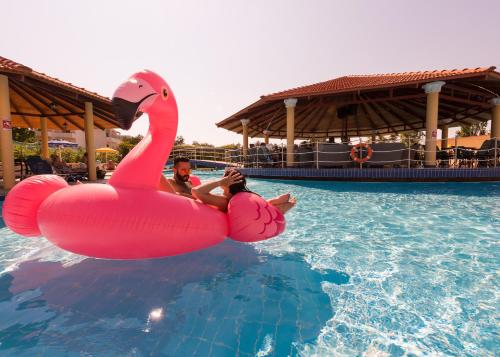 two people in a pink swan in the water at Fantasy Hotel in Kolimbia