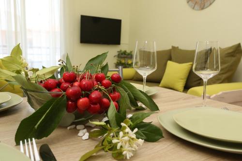 a table with a vase of berries and two wine glasses at Elia in Skála Foúrkas