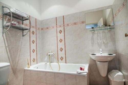 a bathroom with a tub and a sink and a toilet at Hotel Dejmalik in Litoměřice