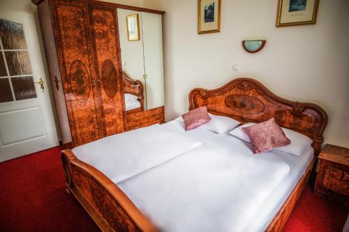 a bedroom with a white bed with two pillows on it at Hotel Dejmalik in Litoměřice