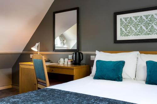 a bedroom with a bed and a desk and a mirror at White Hart by Chef & Brewer Collection in Chalfont Saint Giles